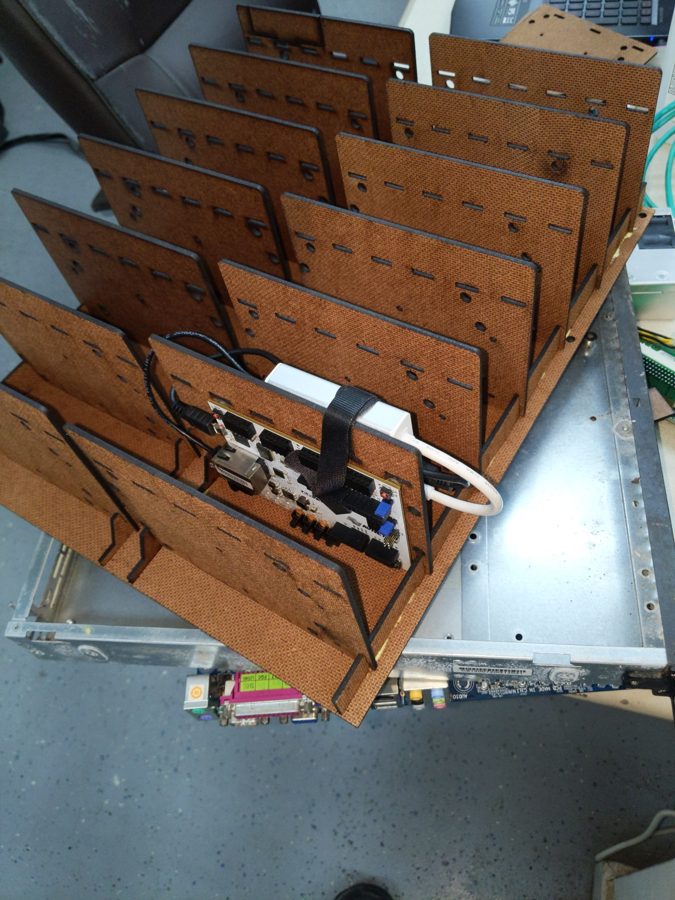 Laser-cut rack of slots holding Raspberry Pis and FPGA boards